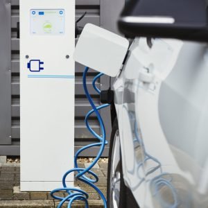 Electric car being charged with a cable connected to a wall socket.